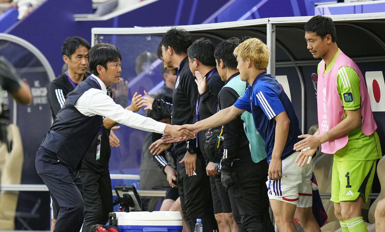 インドネシアに勝利し、ベンチでタッチを交わす森保監督（左手前）（共同）