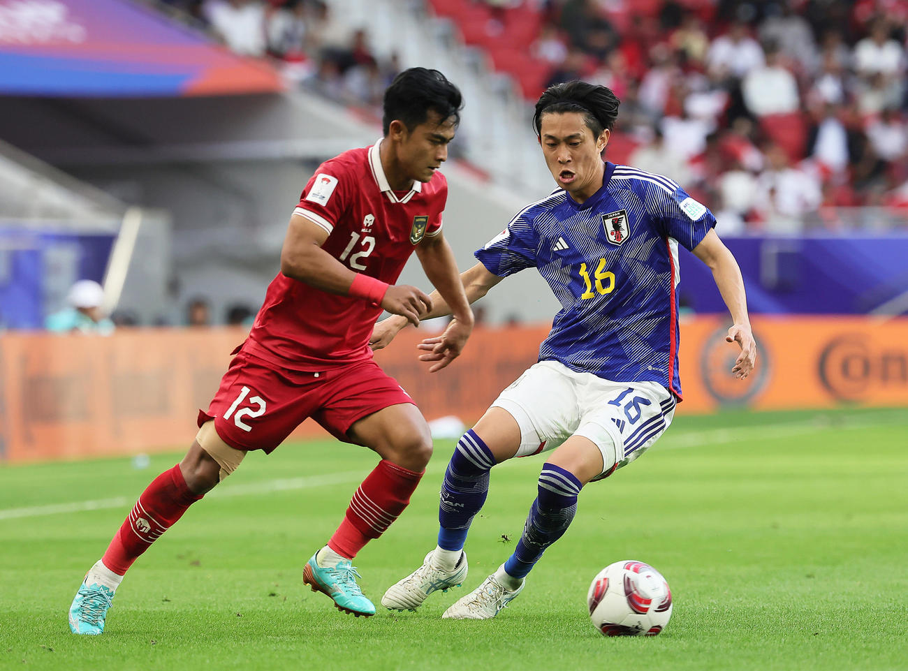 日本対インドネシア　後半、相手と競り合う毎熊（右）（撮影・足立雅史）