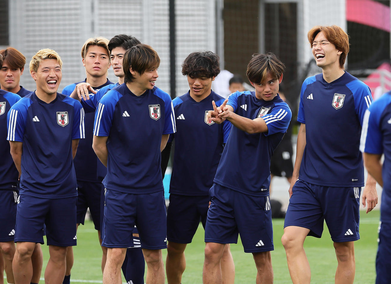 練習見学に訪れたドーハ日本人学校の子どもたちらにポーズを決める久保（右から2人目）を笑顔で見つめる、手前左から堂安、伊東、旗手、1人おいて板倉（撮影・足立雅史）