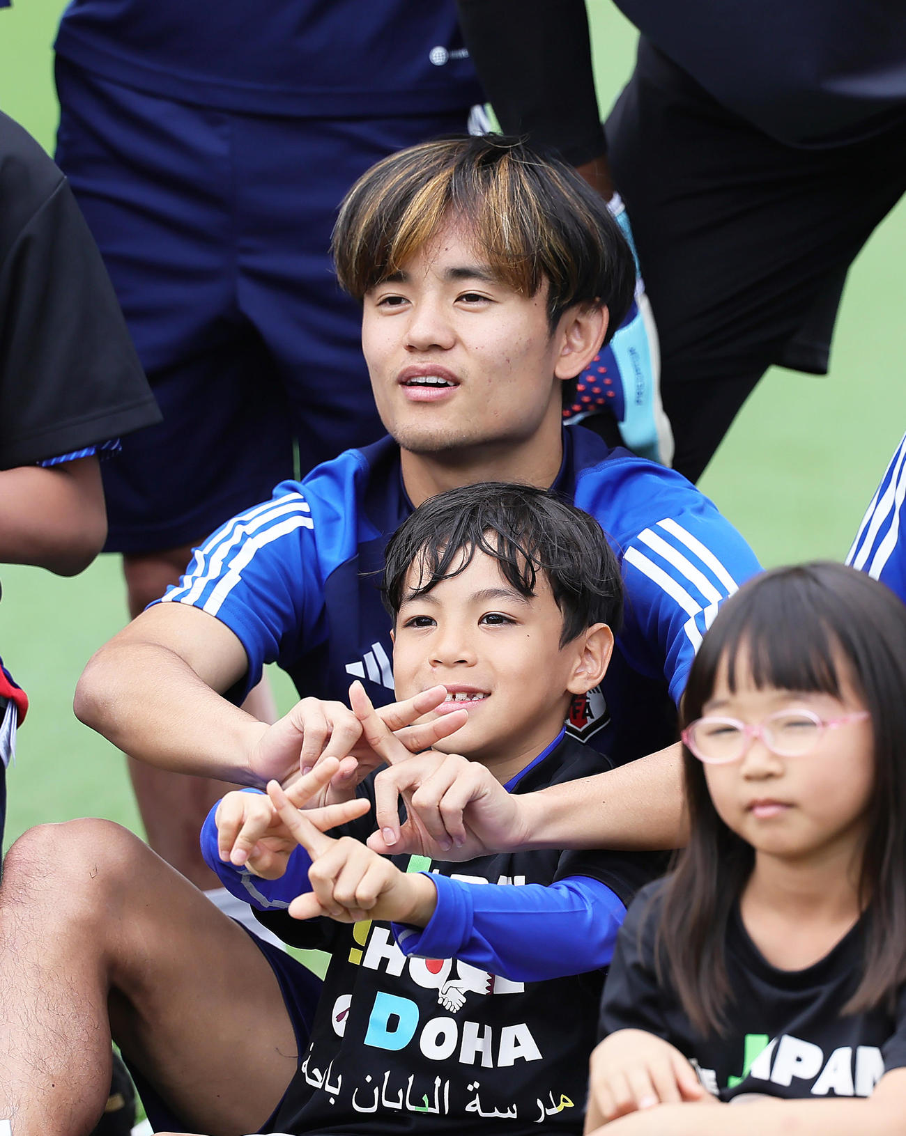 練習見学に訪れたドーハ日本人学校の子どもたちとポーズを決める久保（撮影・足立雅史）