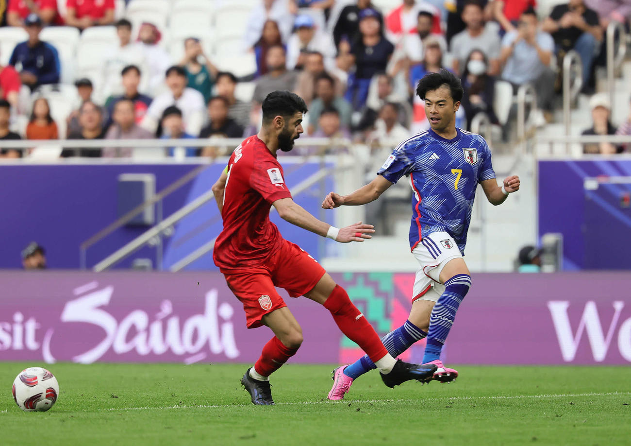日本対バーレーン　後半、ゴール前にパスを出す三笘（右）（撮影・足立雅史）