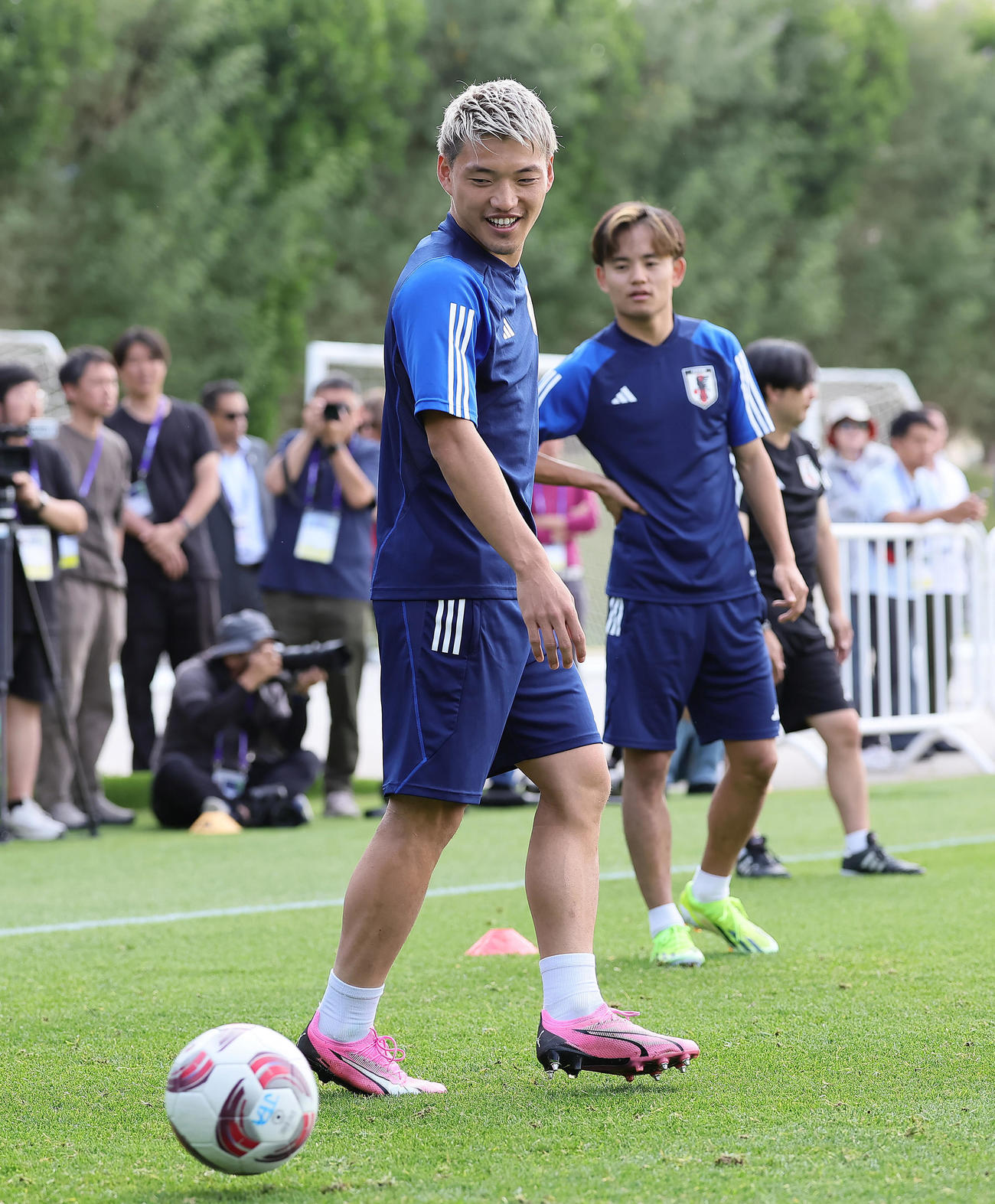 練習中、笑顔を見せる堂安。後方は久保（撮影・足立雅史）