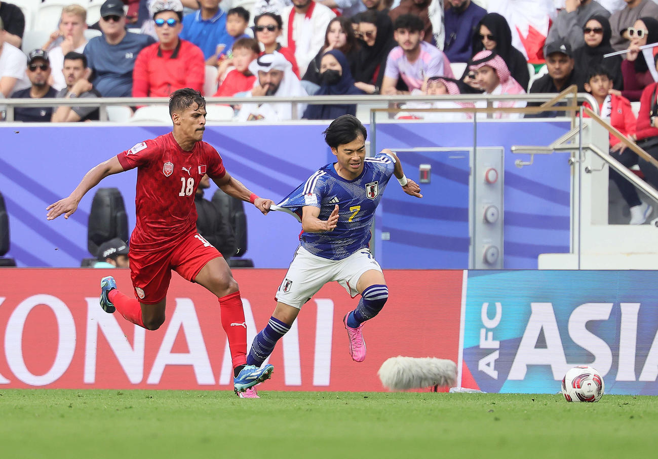 日本対バーレーン　後半、ドリブルで攻めこむ三笘（右）（撮影・足立雅史）