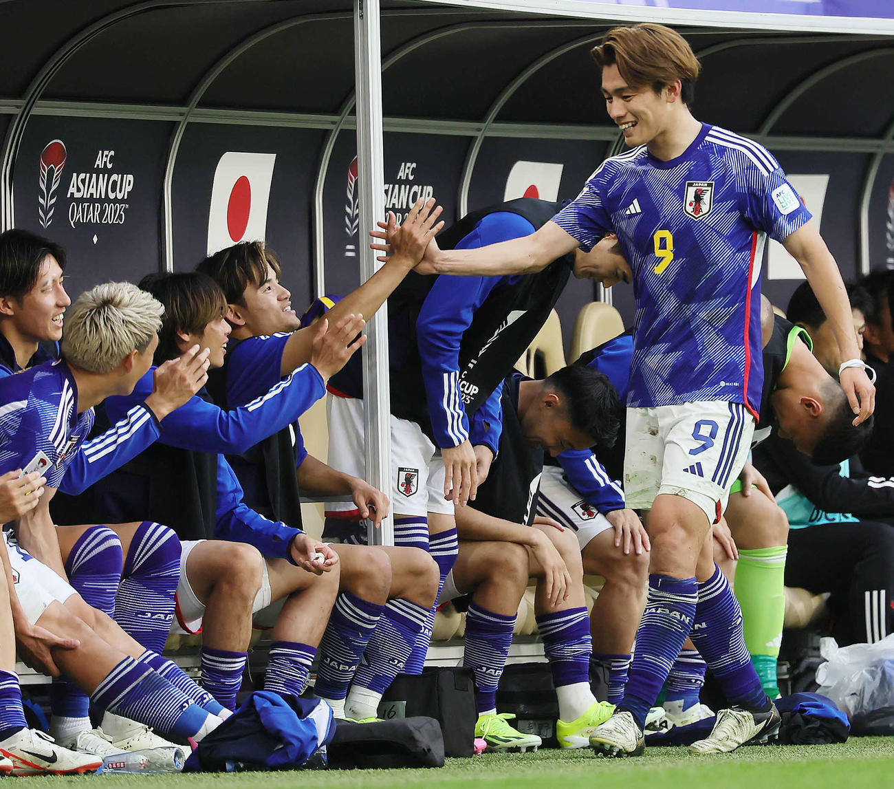 日本対バーレーン　後半、ゴール後、交代でベンチに下がった上田（右端）は久保らと笑顔でタッチを交わす（撮影・足立雅史）