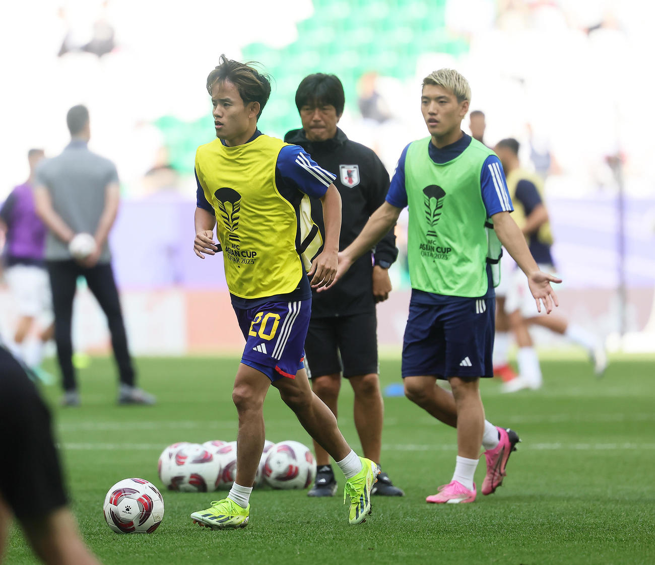 試合前、ウオーミングアップする久保（左）と堂安（撮影・足立雅史）