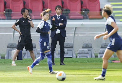 北朝鮮戦直前のウオーミングアップを見守る池田監督(奥右)(共同)