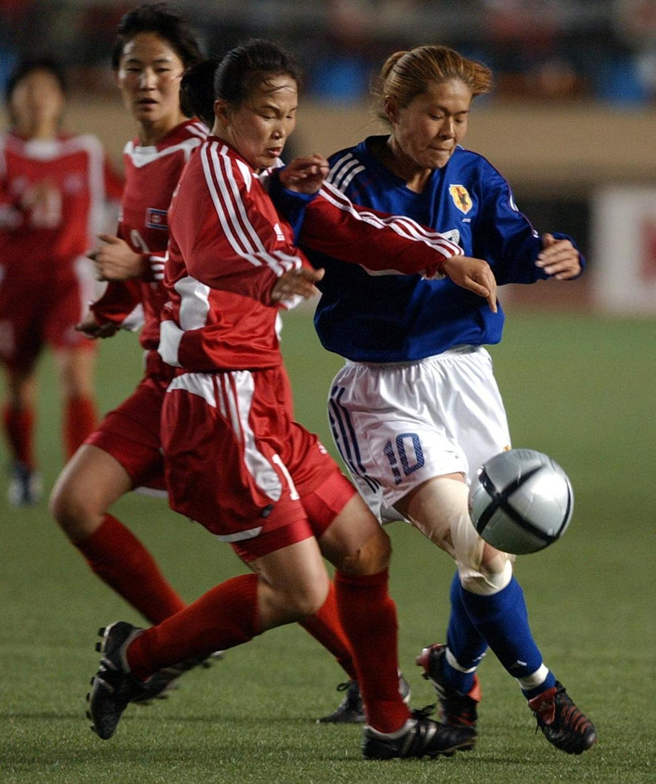 2004年4月24日のアテネ五輪アジア予選準決勝の北朝鮮戦の後半終了間際ヤン・キョンヒ（左）とボールを奪い合う沢穂希