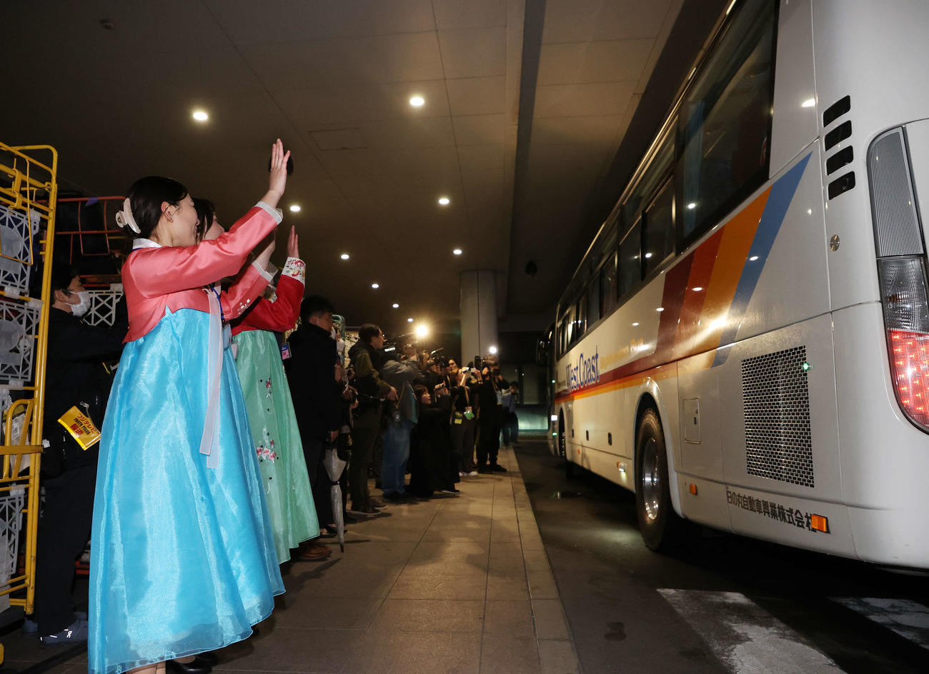 2月25日、サッカー女子北朝鮮代表の選手を乗せたバスを見送る関係者（撮影・鈴木正人）