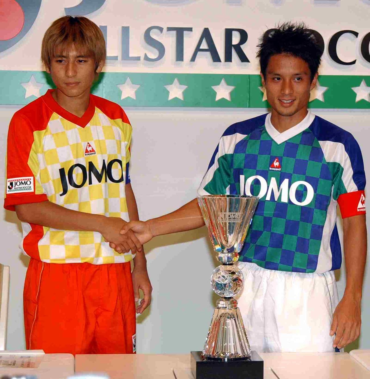オールスターサッカーのユニホーム姿で優勝杯の前で握手を交わす中田浩二（左）と宮本恒靖(2002年8月撮影)