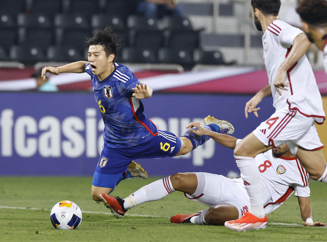 UAE戦の前半、ゴールに迫り倒される川崎（左）（共同）