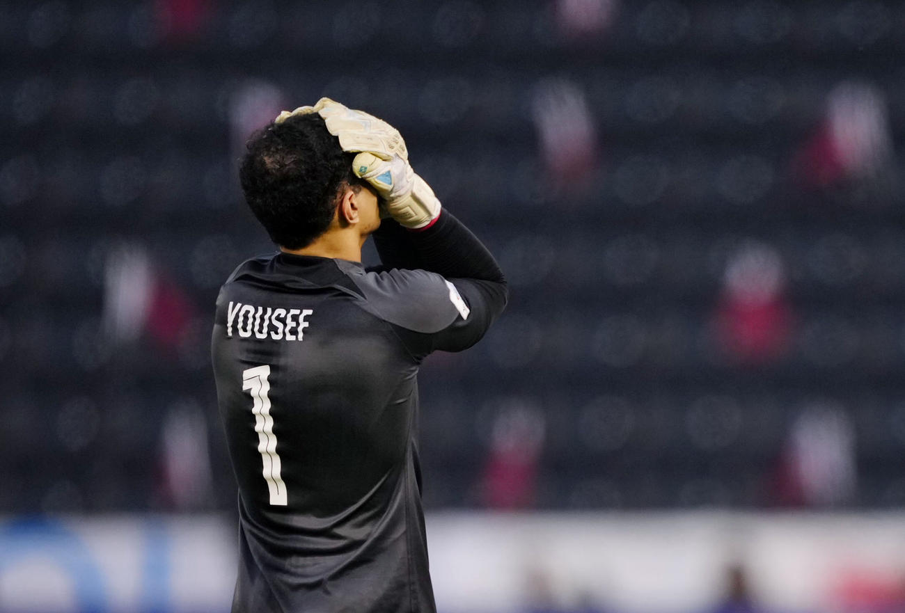 前半、退場処分となり、頭を抱えるカタールのGKアブドラハ（共同）