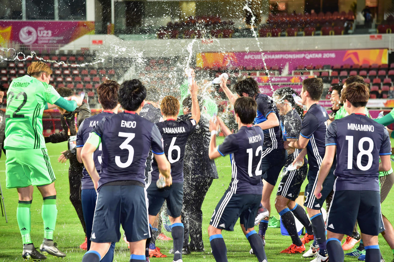 2016年1月26日、日本対イラク　五輪出場を決め選手から喜びで水を浴びせられる手倉森監督（中央）