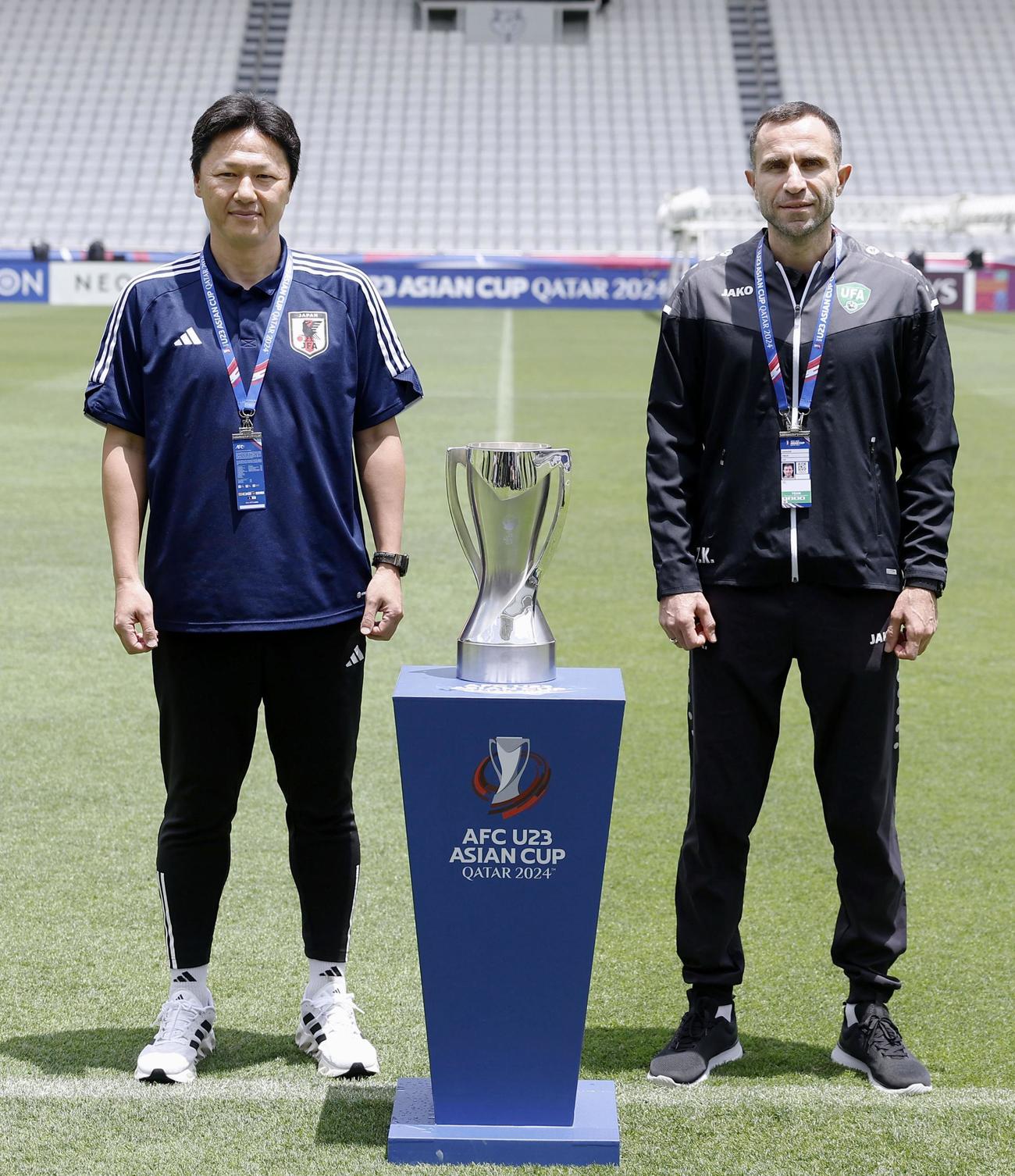決勝を前に試合会場で写真に納まる大岩監督（左）とウズベキスタンのカパーゼ監督（共同）