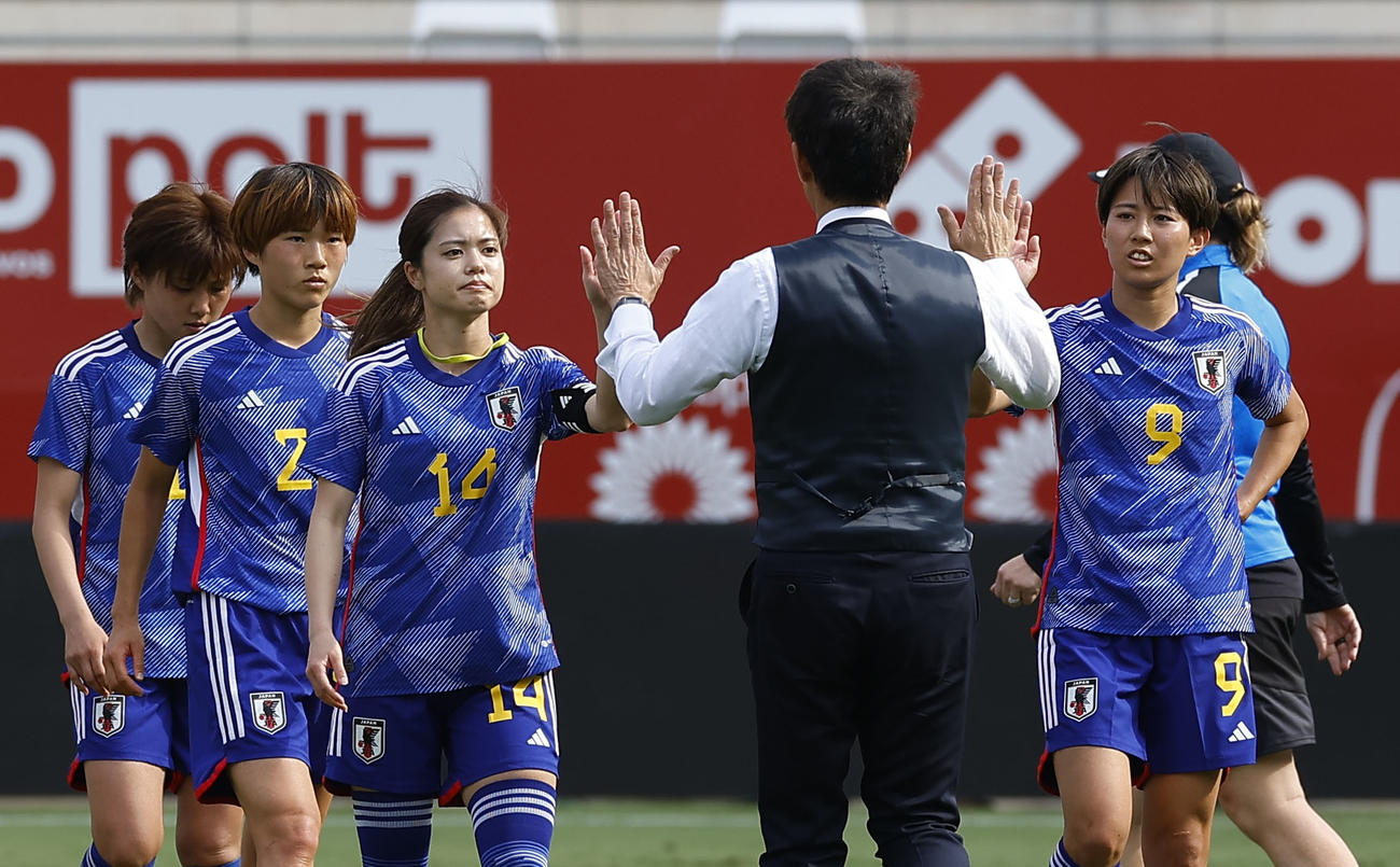 ニュージーランドに勝利し、池田監督とタッチを交わす植木と長谷川（共同）