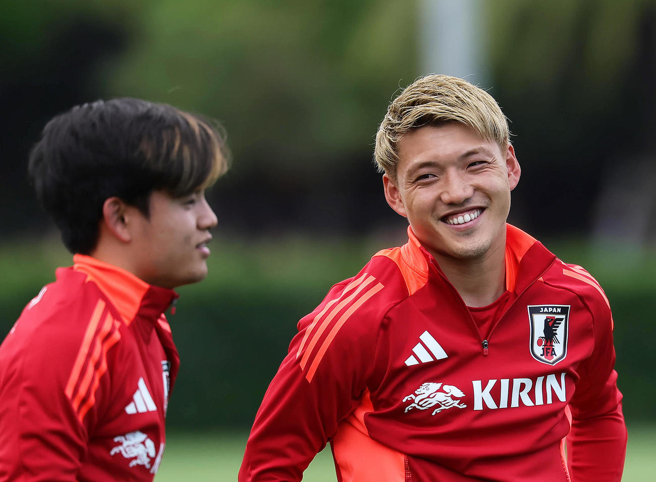 練習中、笑顔を見せる堂安（右）と久保（撮影・足立雅史）