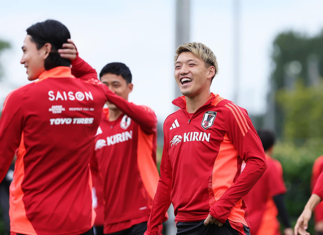 練習中、笑顔を見せる堂安（右）（撮影・足立雅史）