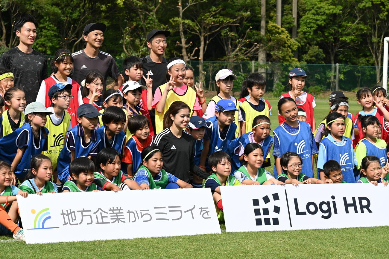 子どもたちと集合写真に収まる長谷川（中央）と桃田（左上）（撮影・飯岡大暉）