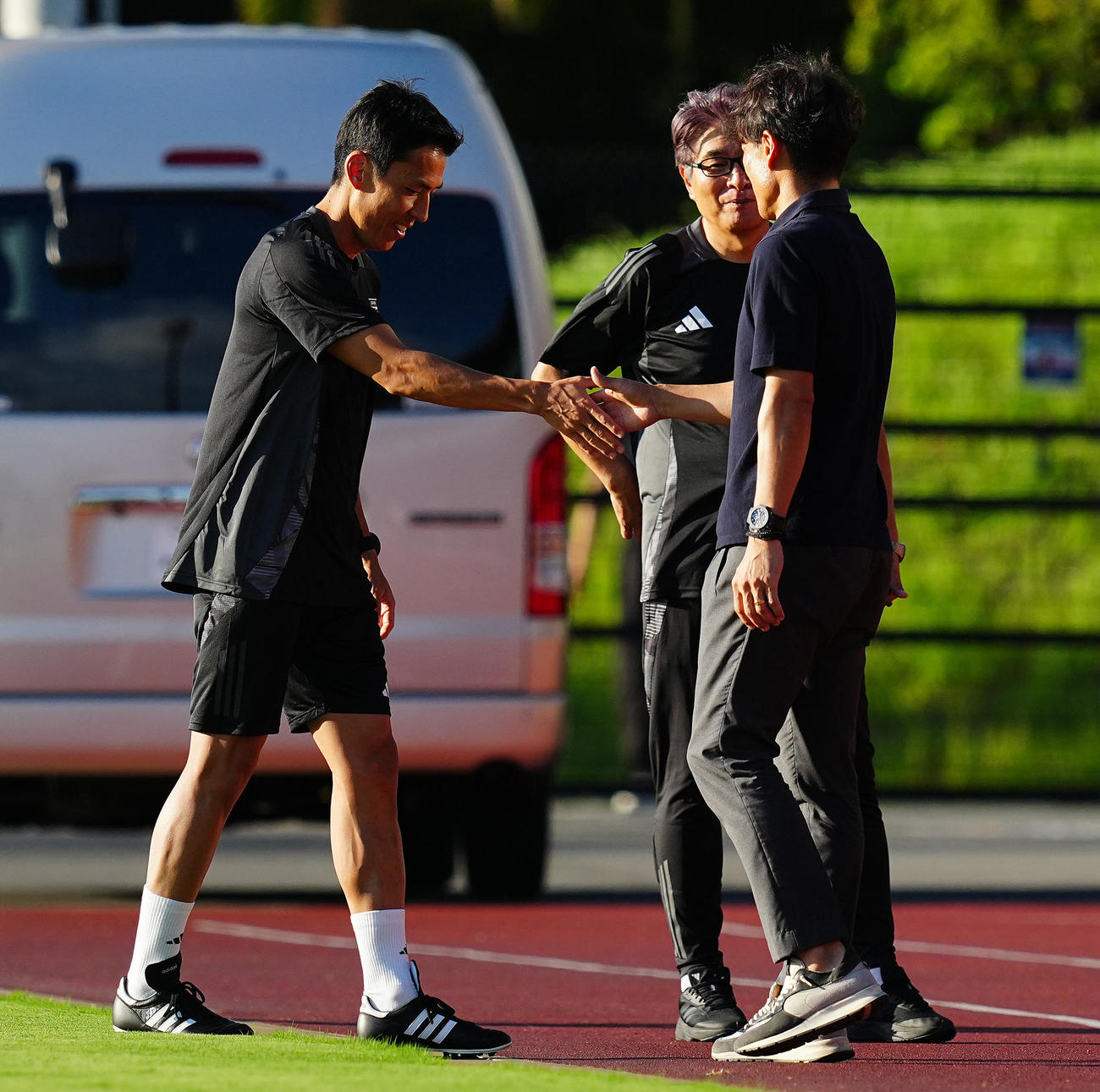 練習前、日本サッカー協会宮本会長（右）にあいさつする長谷部コーチ（撮影・垰建太）