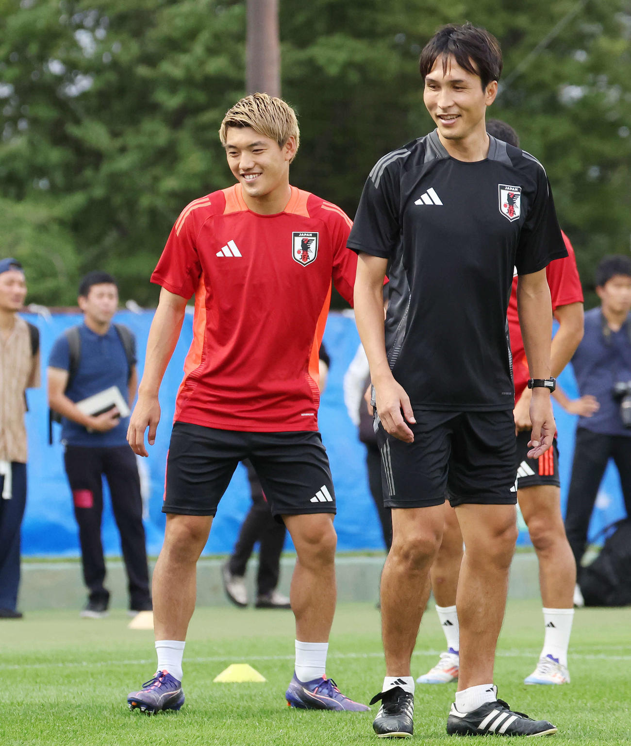 練習で笑顔を見せる堂安（左）と前田コーチ（撮影・宮地輝）