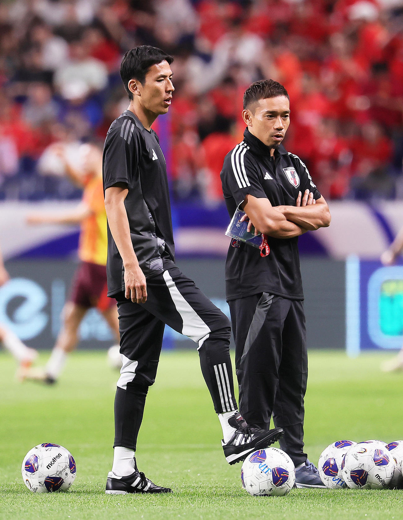 試合前、練習を見つめる長谷部コーチ（左）と長友（撮影・足立雅史）