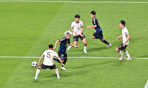 日本対中国　後半、久保（後方）にヒールパスを出す伊東（撮影・滝沢徹郎）　