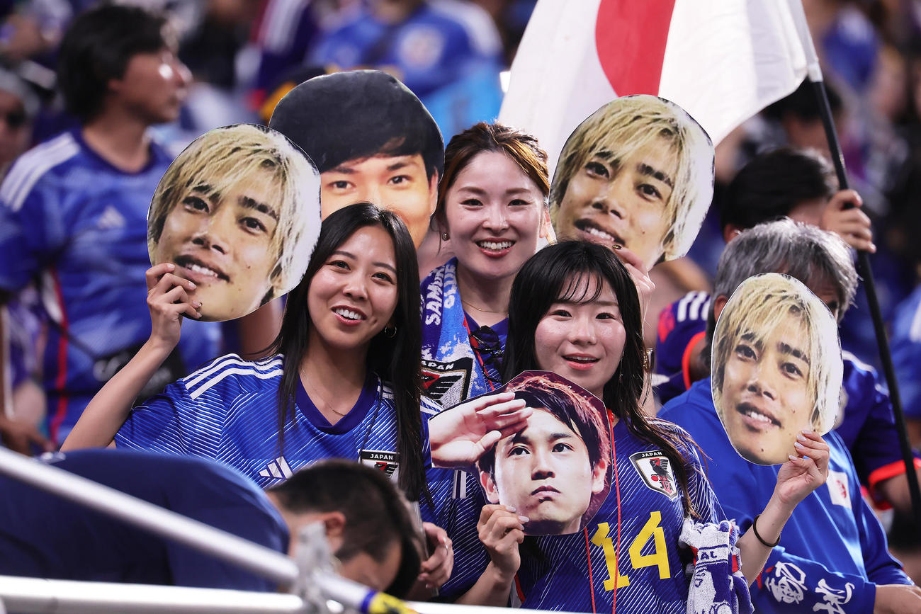 試合前、伊東らのパネルを手に笑顔を見せる日本サポーター（撮影・足立雅史）