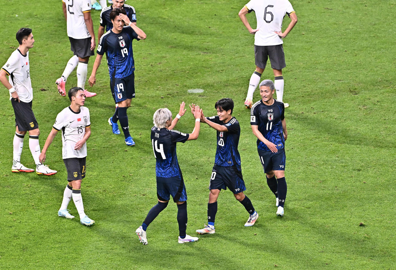 日本対中国　後半、ゴールを決めた久保（中央左）は伊東とタッチをかわす（撮影・滝沢徹郎）　