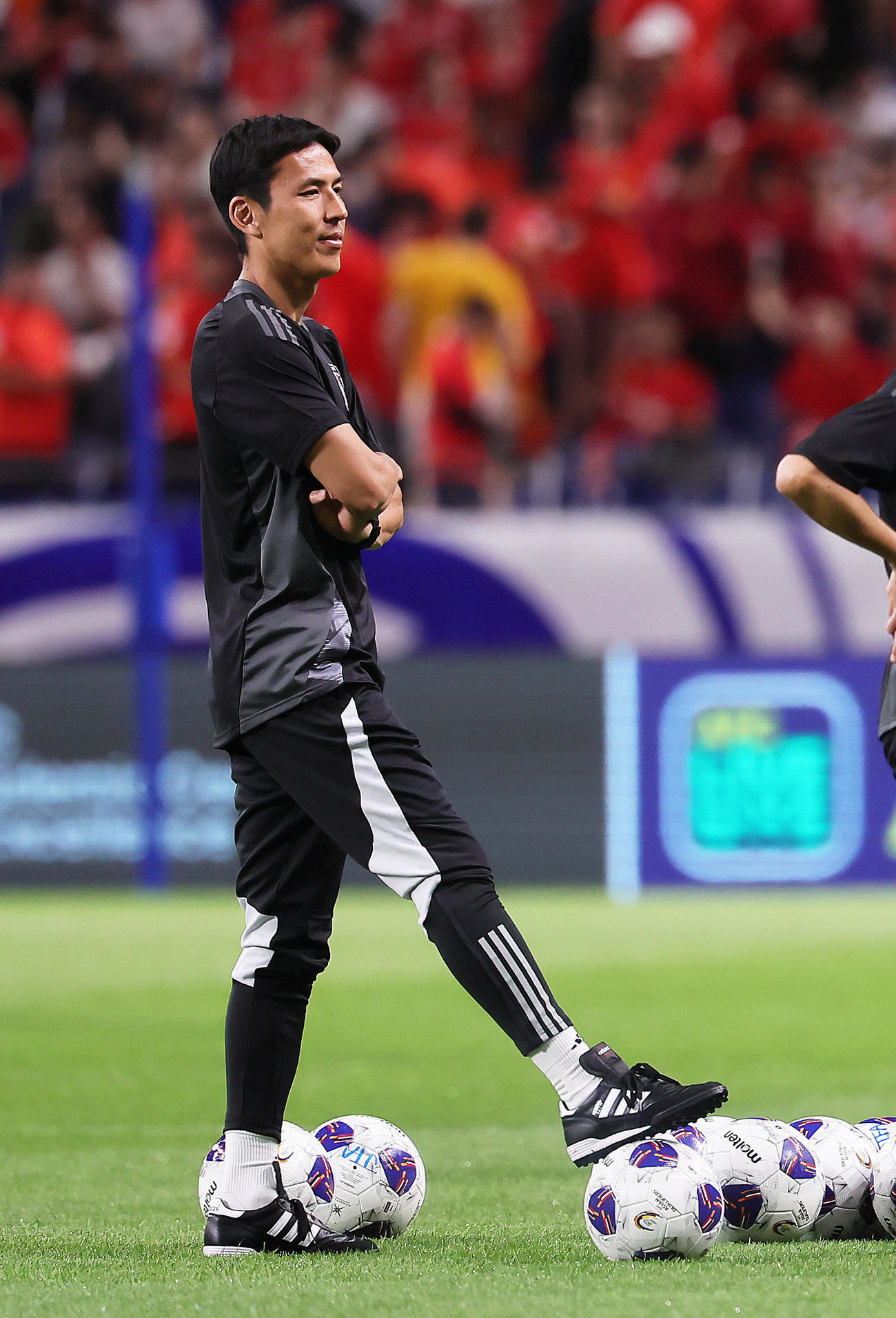 試合前、練習を見つめる長谷部コーチ（撮影・足立雅史）