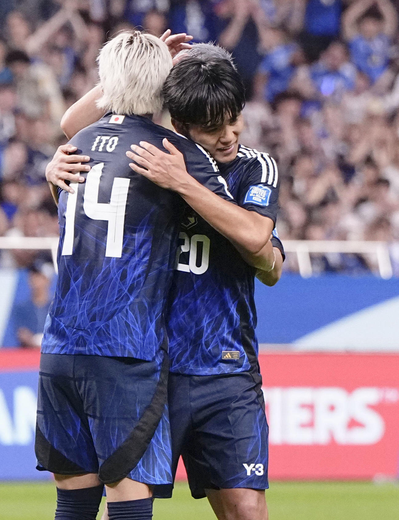 日本―中国　試合終了間際、チーム7点目のゴールを決め、伊東と抱き合う久保（右）＝埼玉スタジアム（共同）