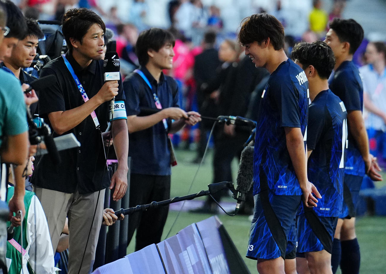 7月24日、パリ五輪サッカー男子　日本対パラグアイ　試合後の選手たちに話しを聞く内田氏（左）