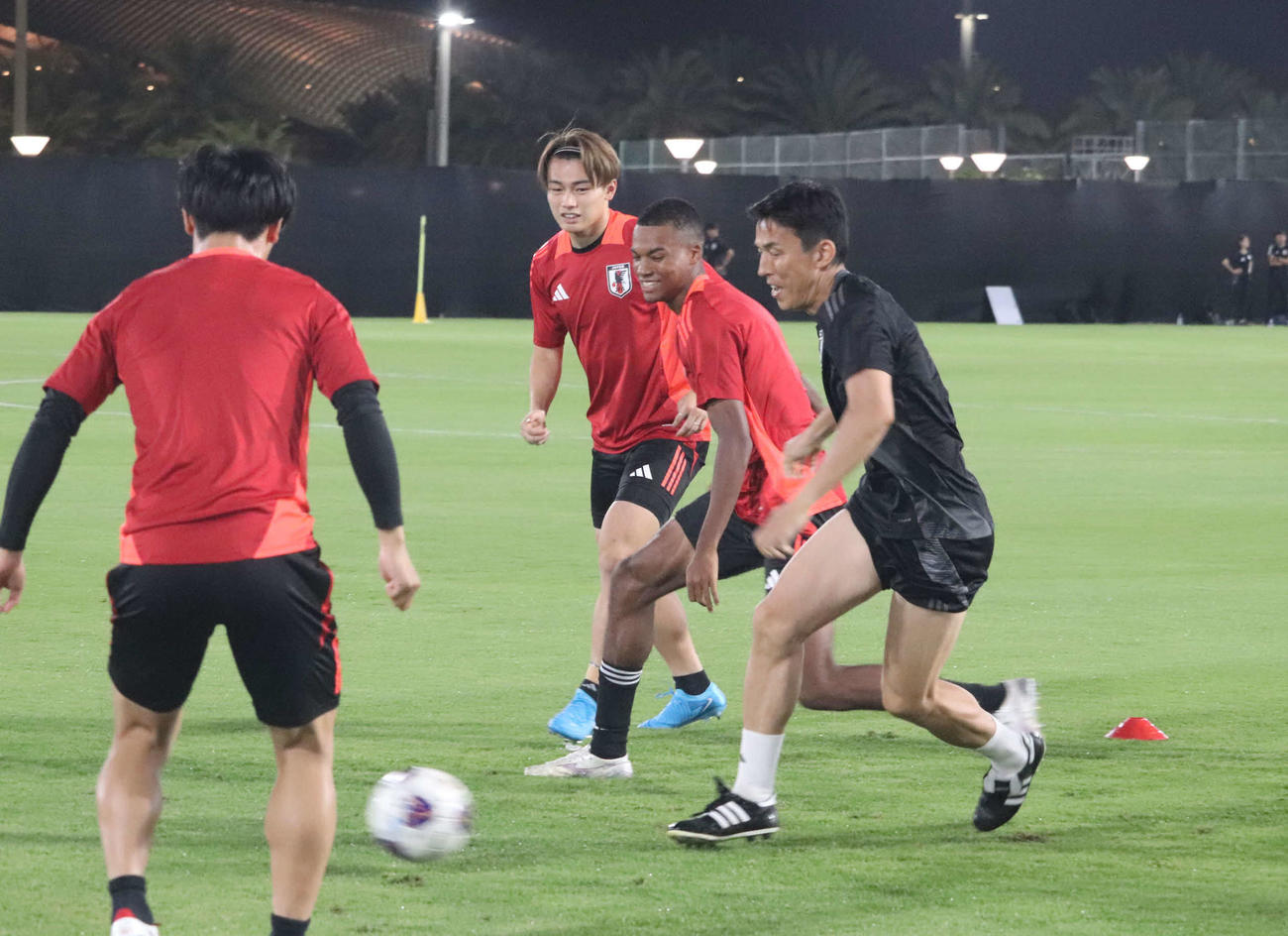 長谷部コーチ（右）をまじえボール回しをするMF藤田（右から2人目）とFW上田