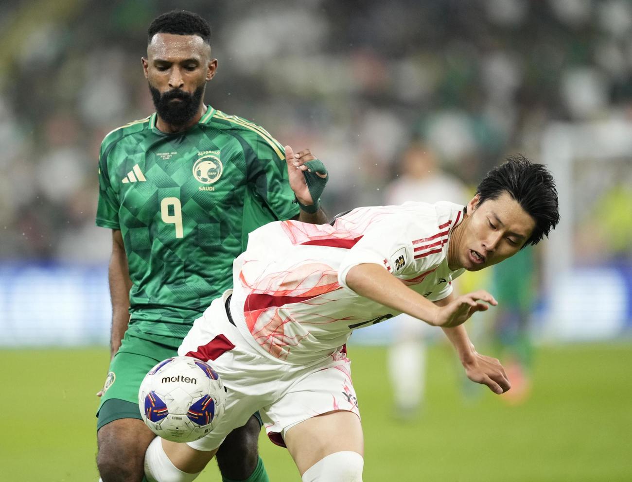 日本―サウジアラビア　後半、激しく競り合う鎌田（右）＝ジッダ（共同）