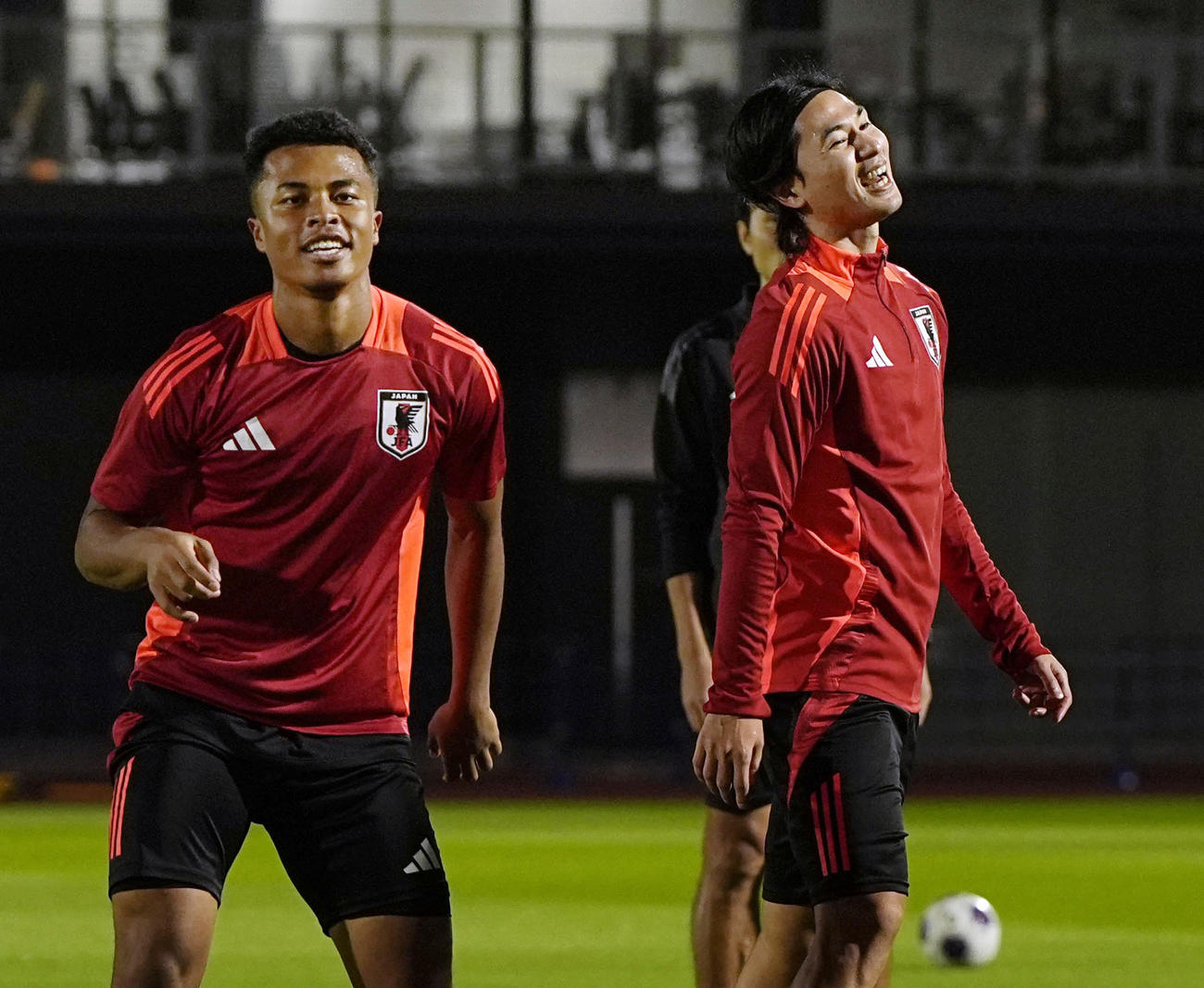 サッカーW杯アジア最終予選のオーストラリア戦に向けた練習で、笑顔を見せる藤田（左）と南野（共同）