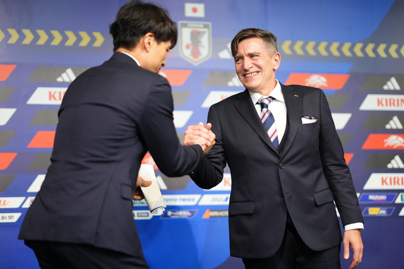 会見を終え握手を交わすニルス・ニールセン新監督（右）と宮本恒靖会長（撮影・横山健太）
