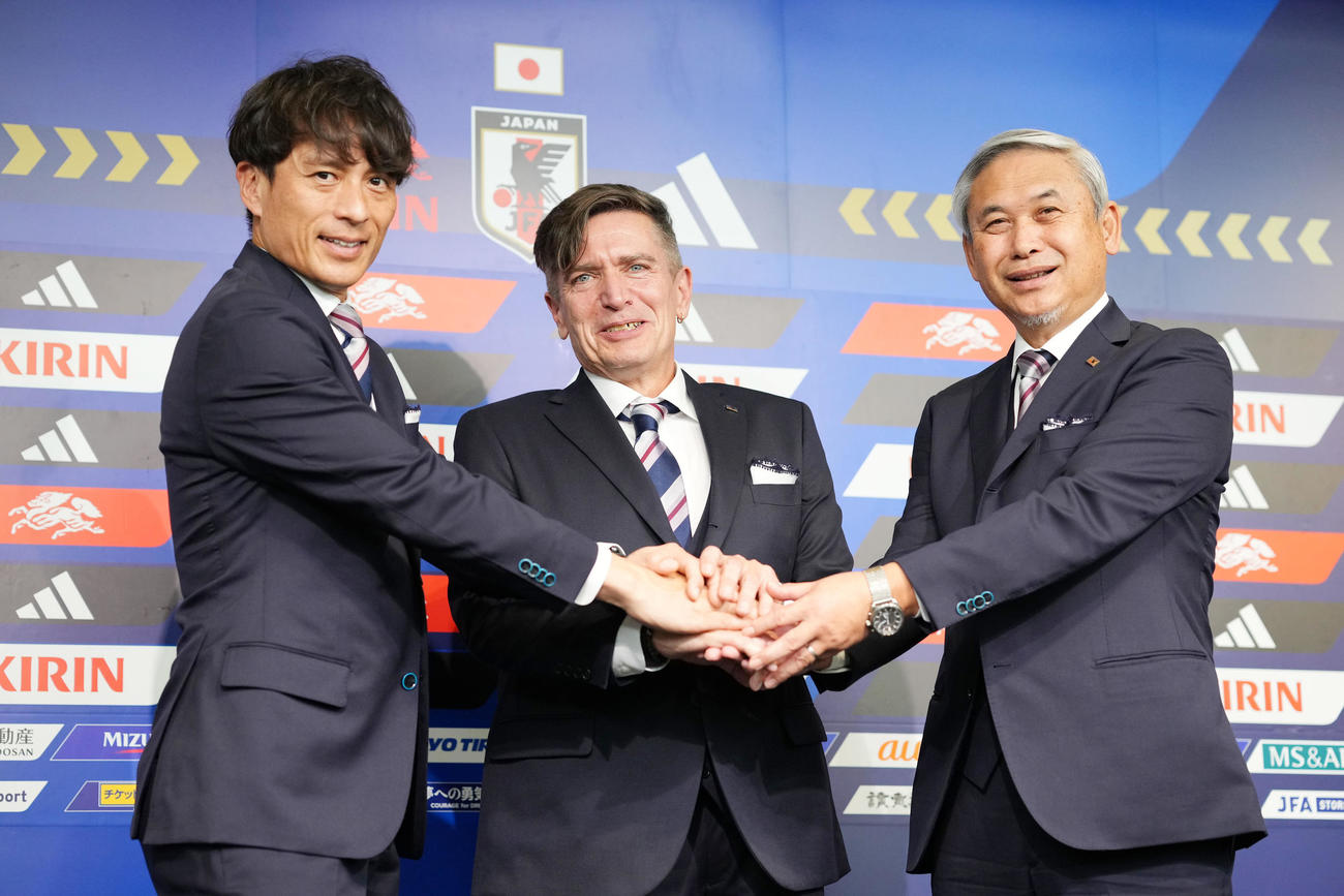 握手を交わす、左から宮本恒靖会長、ニルス・ニールセン新監督、佐々木則夫委員長（撮影・横山健太）
