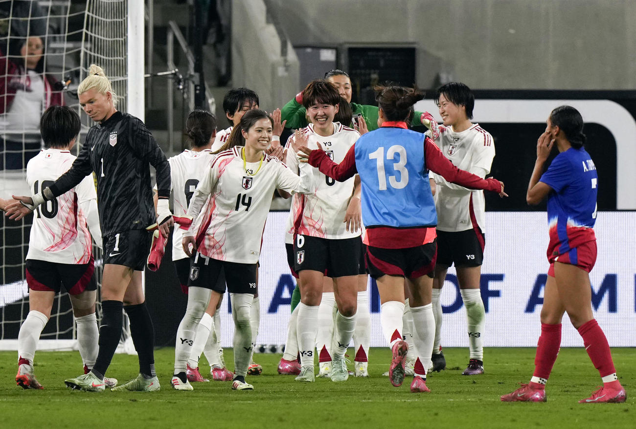 米国に競り勝ち、タッチを交わす女子日本代表（共同）