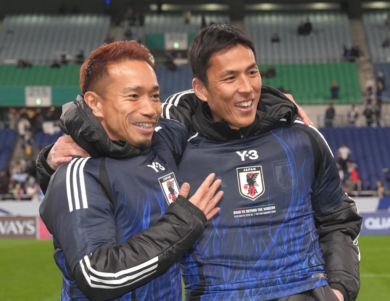 日本対バーレーン　W杯出場を決め、笑顔を見せる長友（左）と長谷部コーチ（撮影・足立雅史）