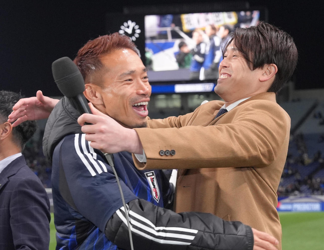 日本対バーレーン　W杯出場を決めた長友（左）は中継を務める内田氏と抱き合い喜ぶ（撮影・足立雅史）