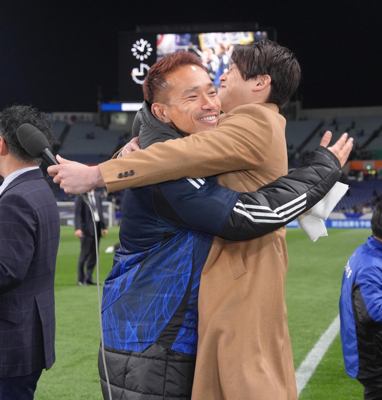 日本対バーレーン　W杯出場を決めた長友（左）は中継を務める内田氏と抱き合い喜ぶ（撮影・足立雅史）