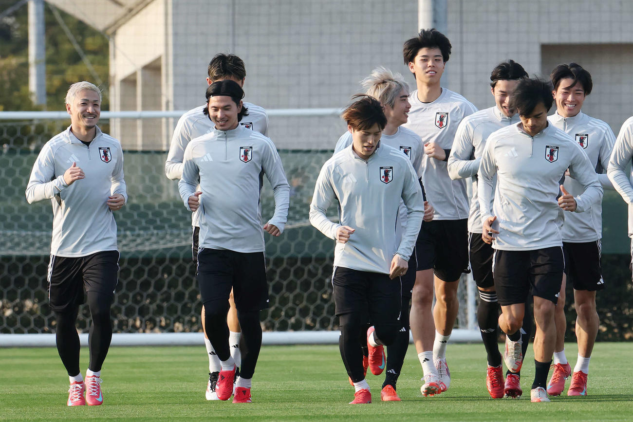 笑顔でランニングする、左から前田、南野、古橋、伊東、高井、中山、三笘、中村（撮影・宮地輝）