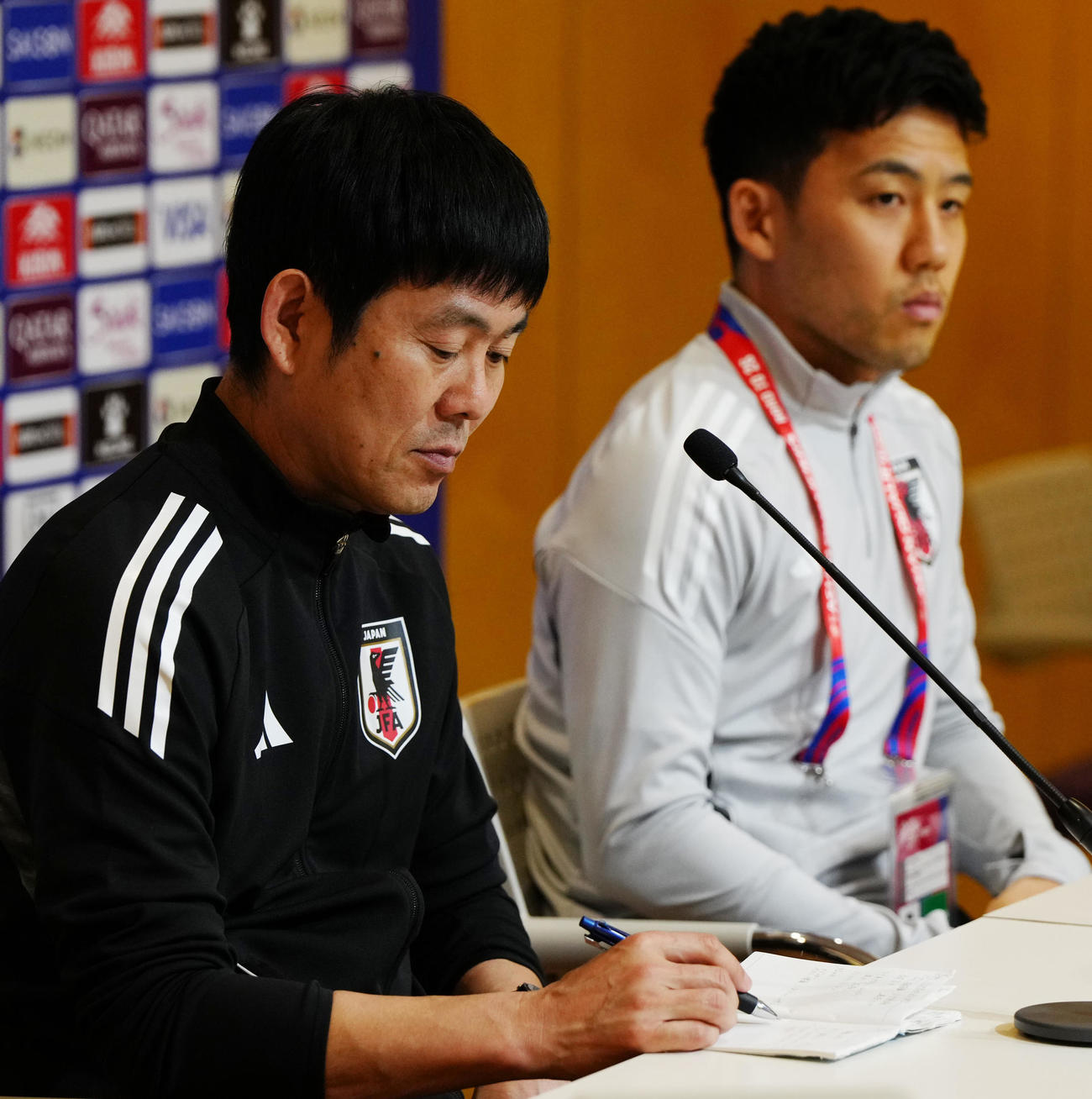 サウジアラビア戦の前日会見でノートにメモをとる森保監督。右は遠藤（撮影・江口和貴）