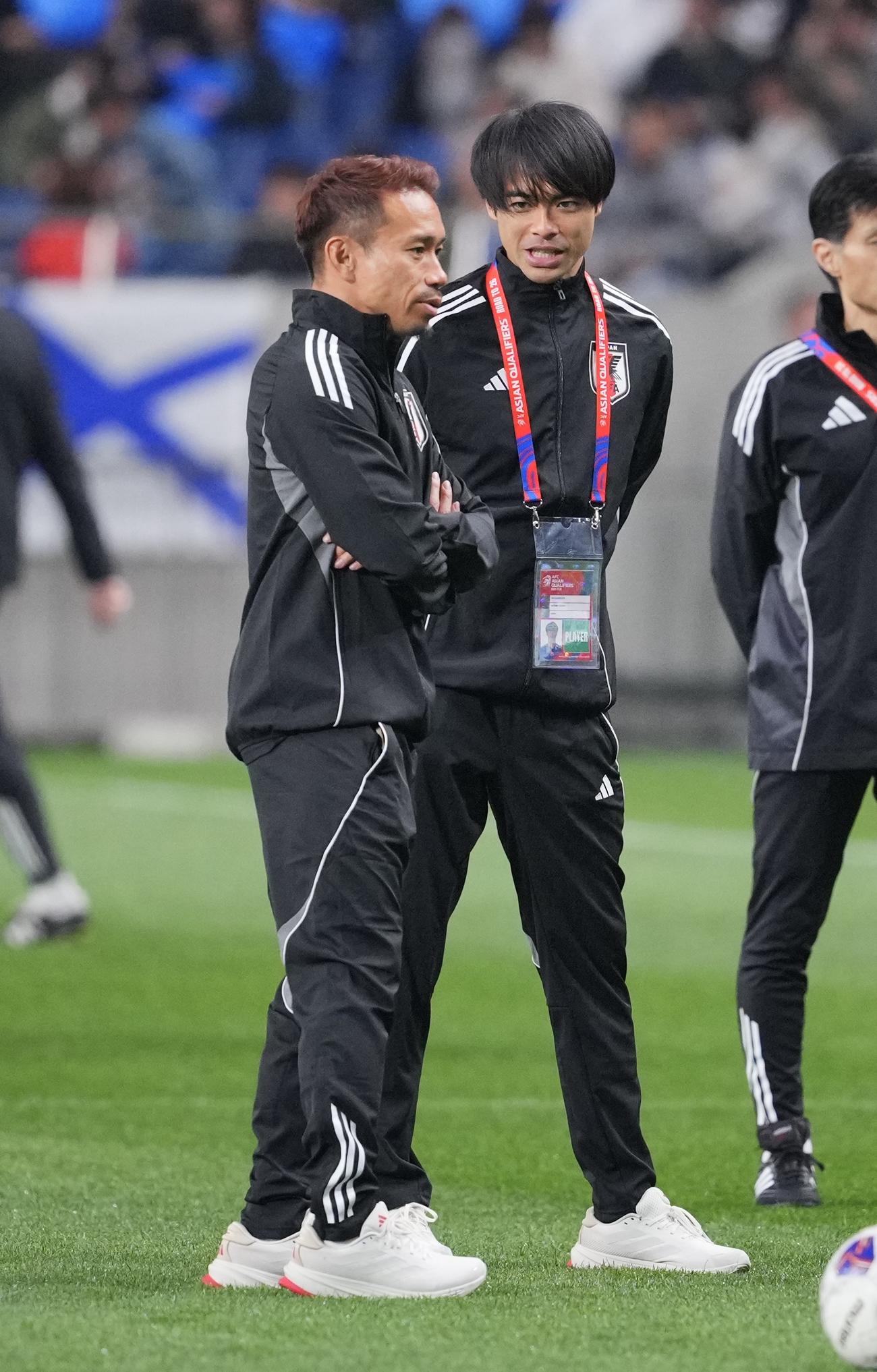日本対サウジアラビア　試合前、選手たちの練習を見つめる三笘（右）と長友（撮影・垰建太）