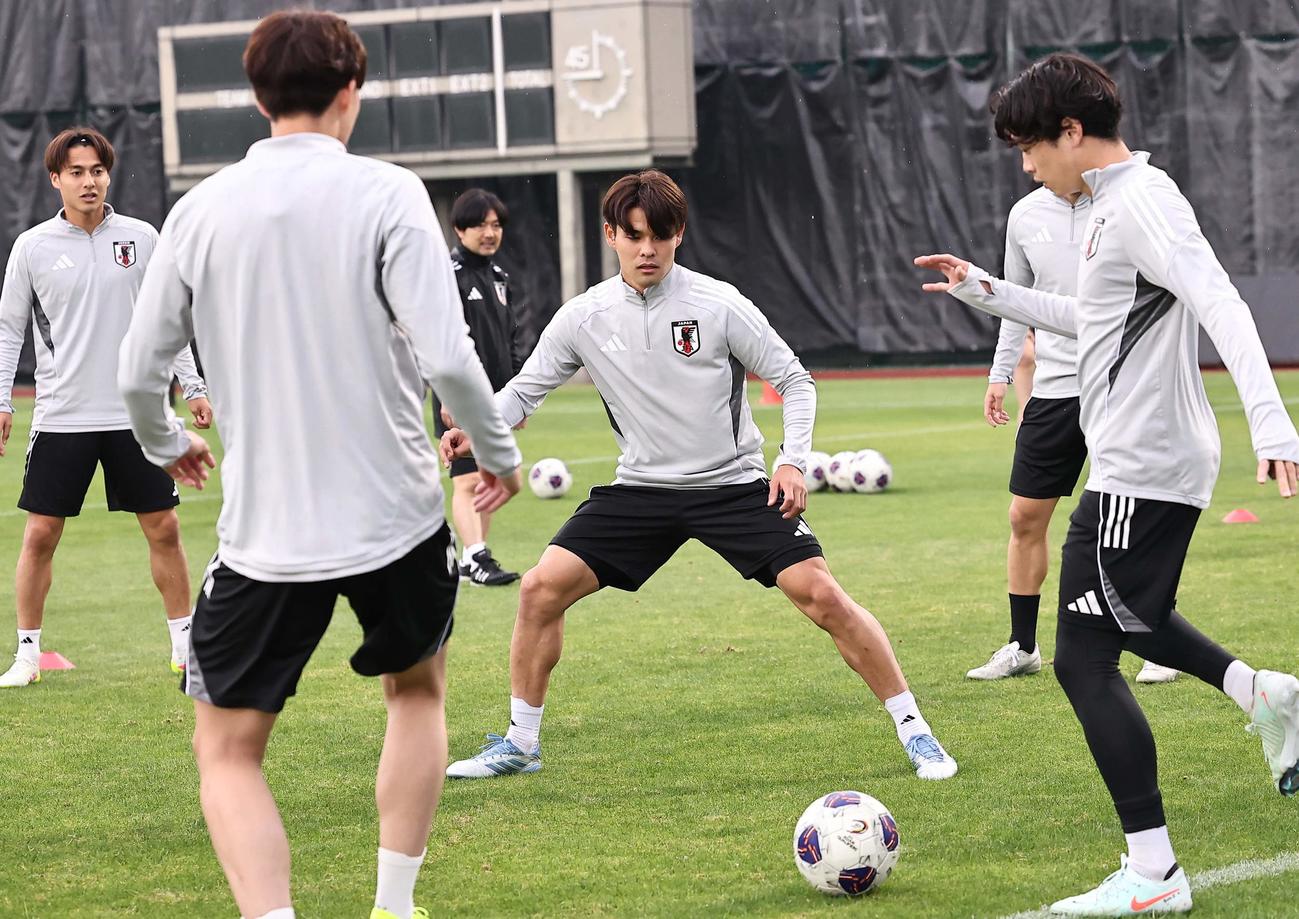 日本代表佐野海（中央）はほかの選手とボール回しをする（撮影・上田博志）