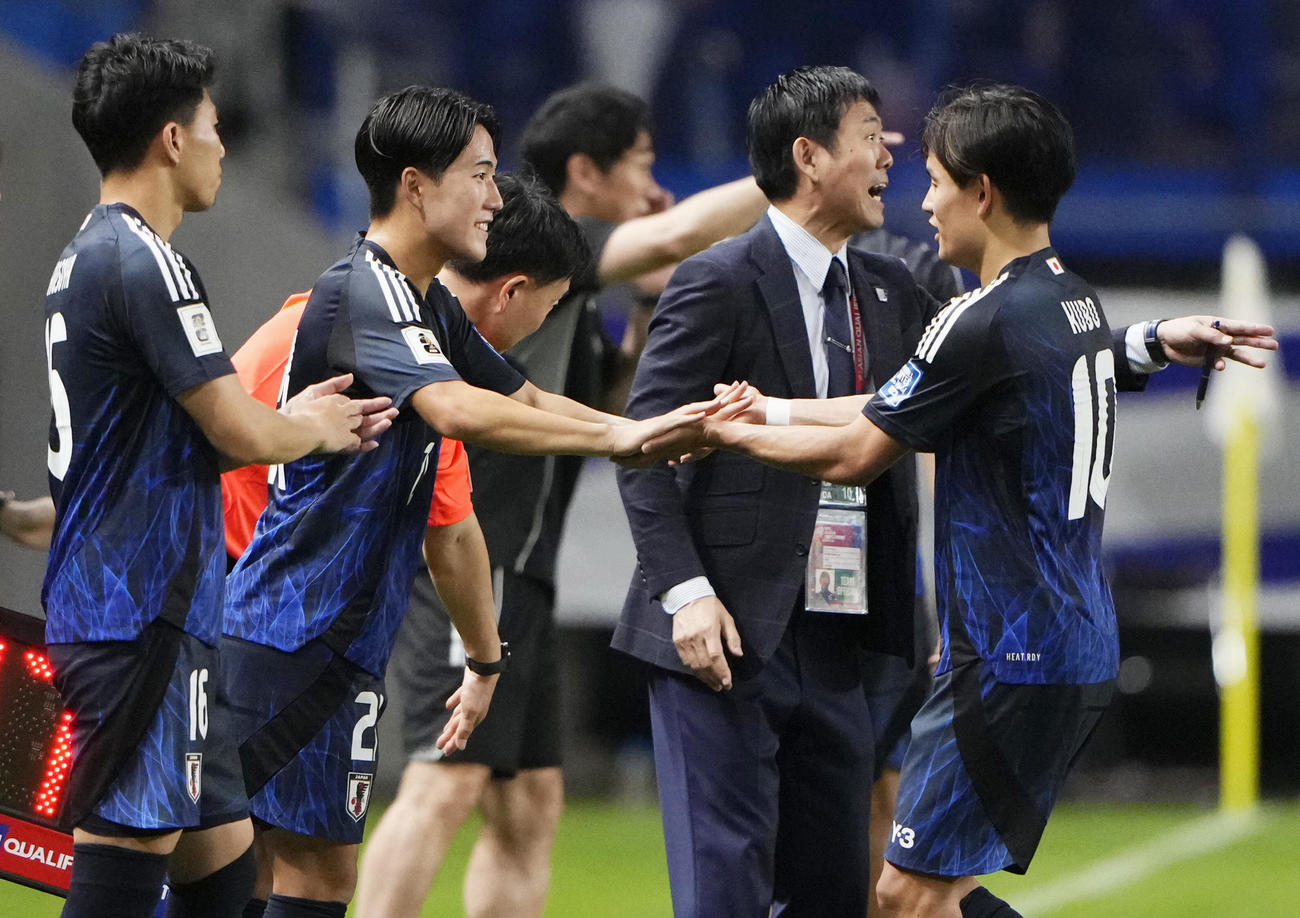 後半、久保とタッチを交わし途中出場する佐藤（左から2人目）（共同）