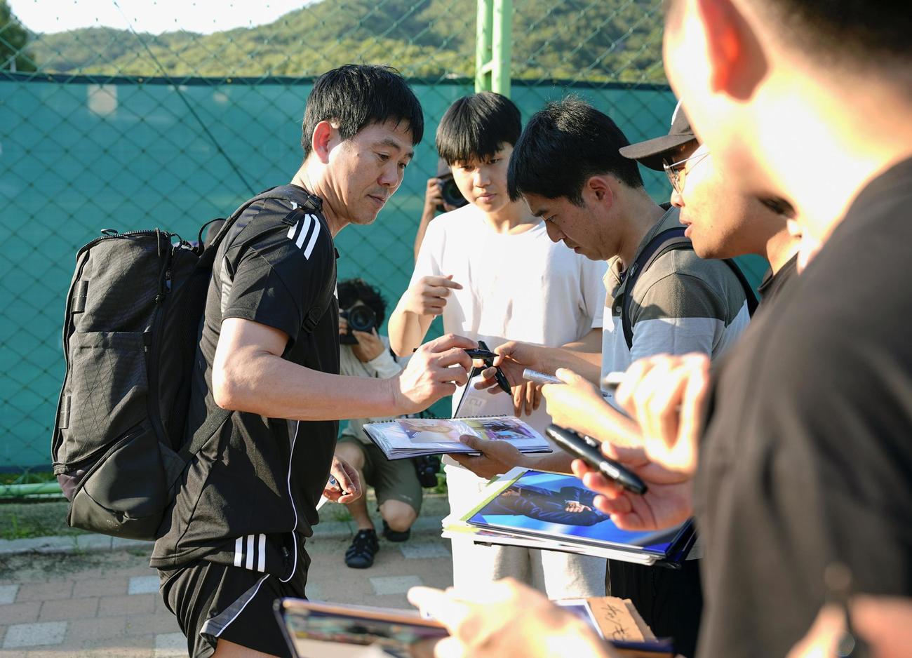 中国戦に向けた練習を終え、サインの求めに応じる森保監督（左、共同）
