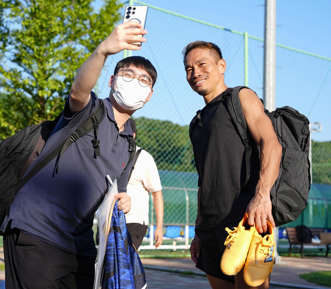 中国戦に向けた練習を終え、写真撮影に応じる長友（右）＝安養（共同）