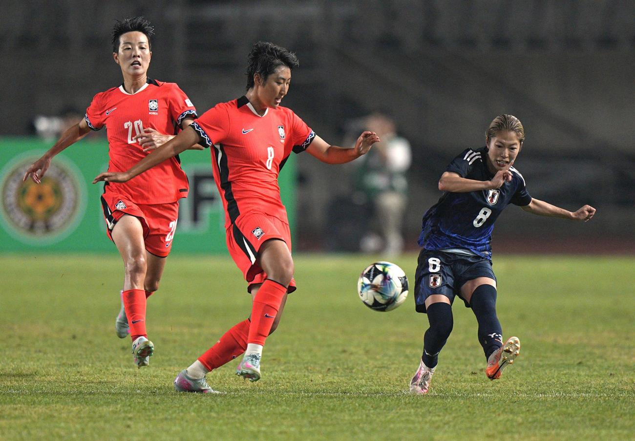 日本対韓国　後半、パスを出す成宮（右）（共同）
