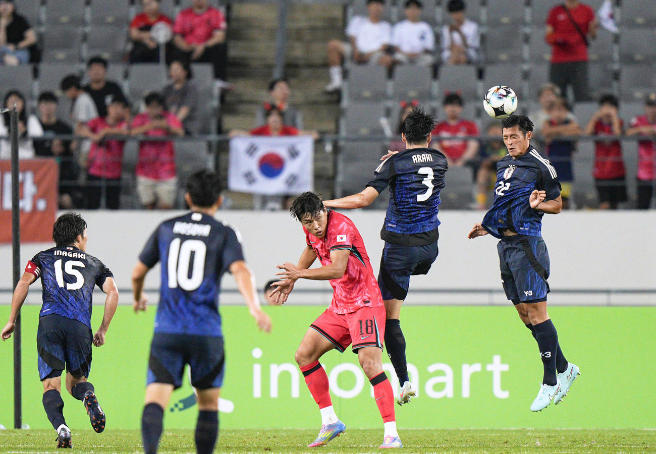 日本対韓国　後半、ヘディングでクリアする植田（右端）（共同）