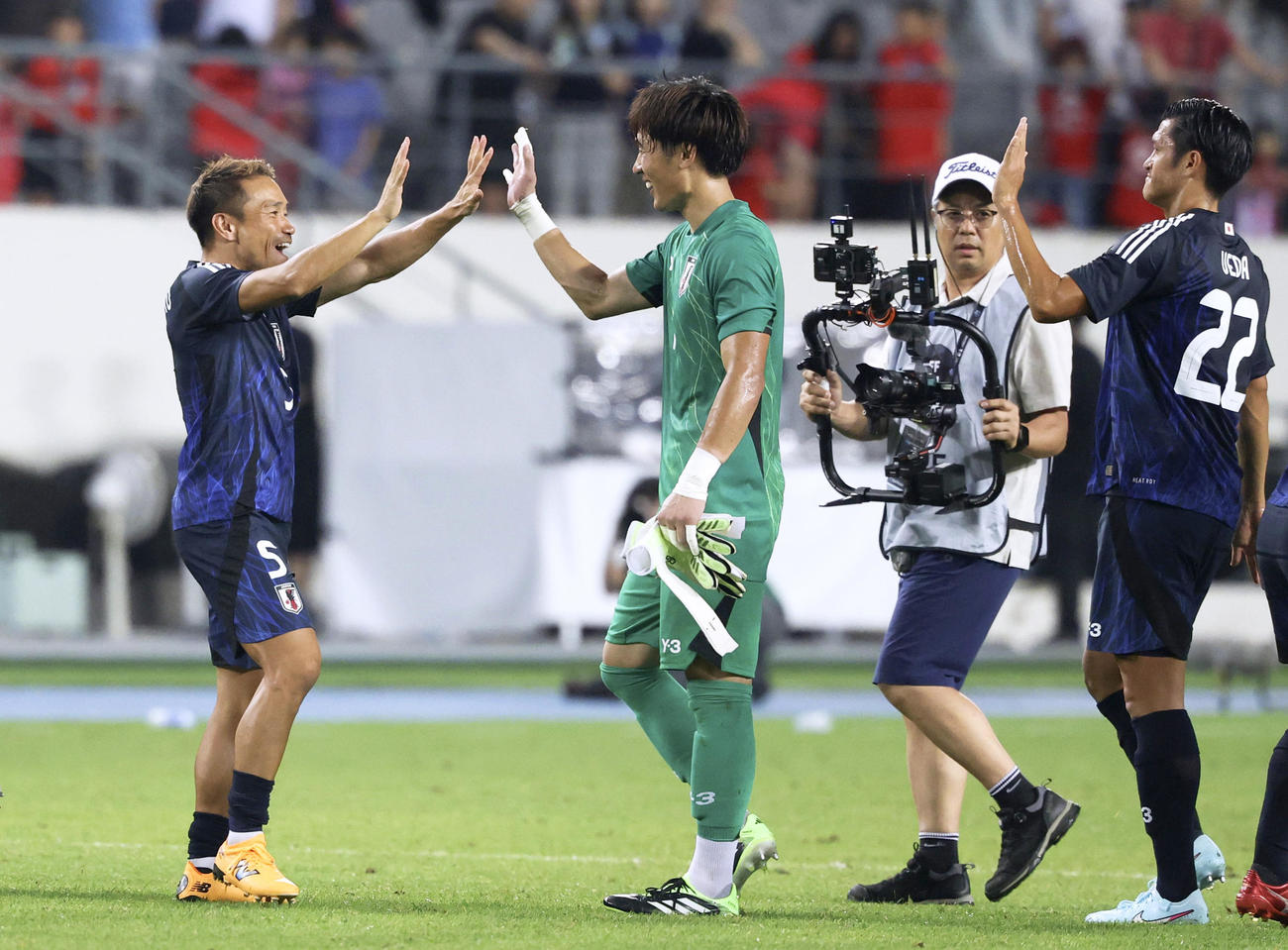 日本対韓国　韓国に競り勝ち、GK大迫とタッチを交わす長友（左）（共同）