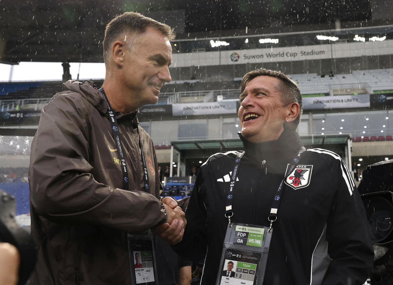 試合開始前、中国のミリチッチ監督と握手を交わすニールセン監督（右、共同）